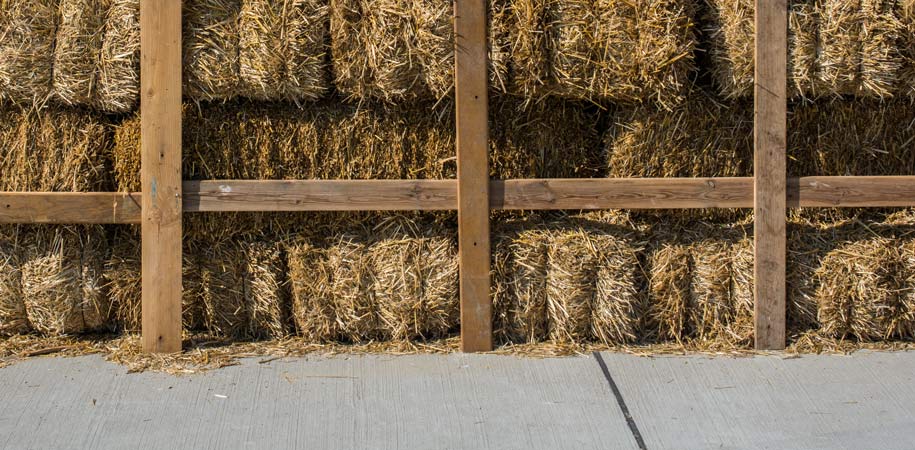 Hay stacked in storage with wooden enclosure