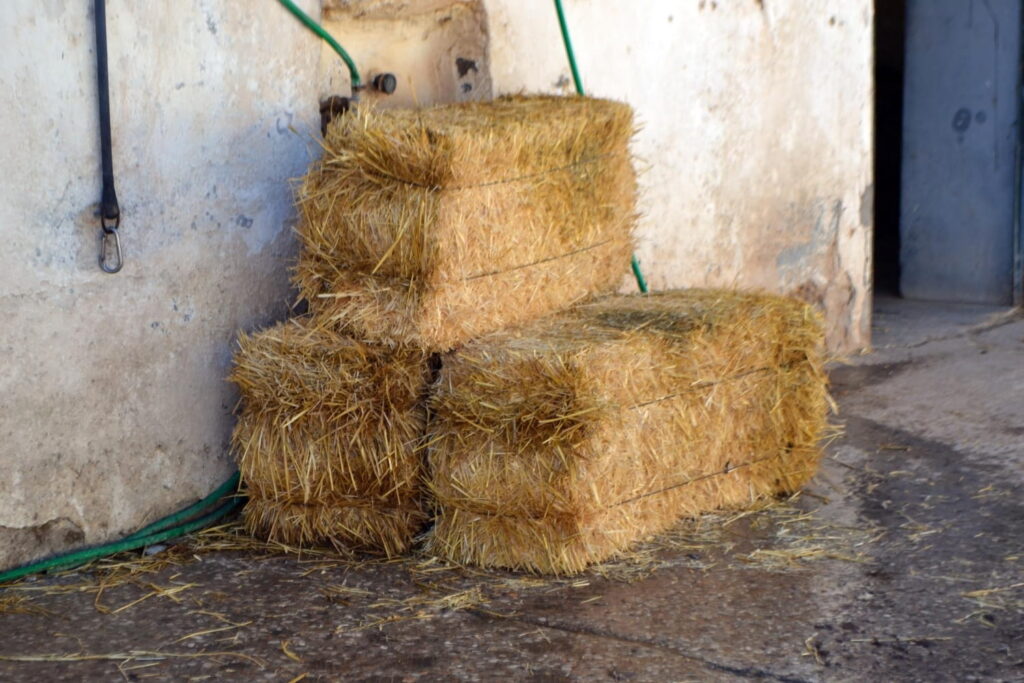stacked hay bales in rustic spanish setting